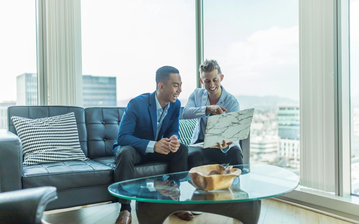 two men in suit sitting on sofa by Austin Distel courtesy of Unsplash.
