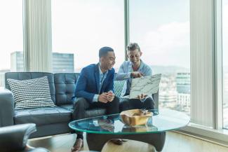two men in suit sitting on sofa by Austin Distel courtesy of Unsplash.